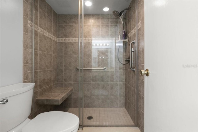full bath featuring a shower stall and toilet