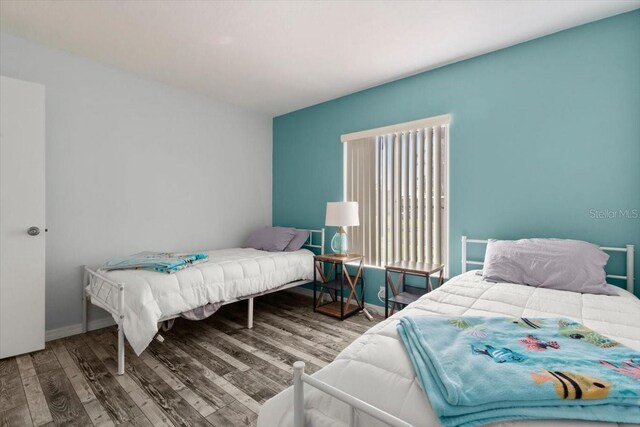 bedroom featuring wood finished floors and multiple windows