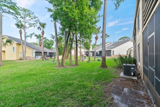 view of yard featuring a residential view and central AC unit