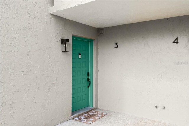 doorway to property featuring stucco siding