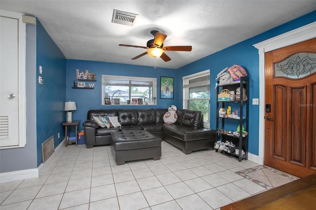 living area featuring visible vents, baseboards, ceiling fan, and light tile patterned floors