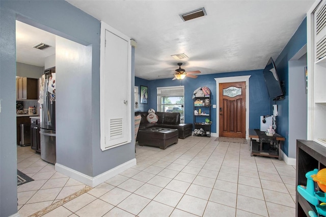 entryway with light tile patterned floors, baseboards, ceiling fan, and visible vents