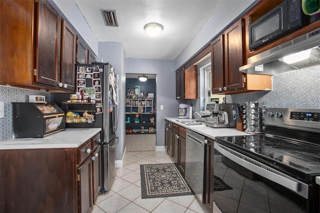 kitchen featuring a sink, stainless steel appliances, light tile patterned floors, tasteful backsplash, and visible vents