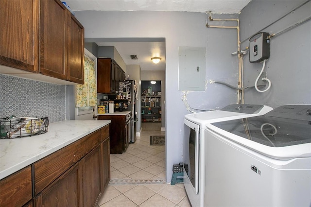 washroom with cabinet space, separate washer and dryer, light tile patterned floors, visible vents, and electric panel