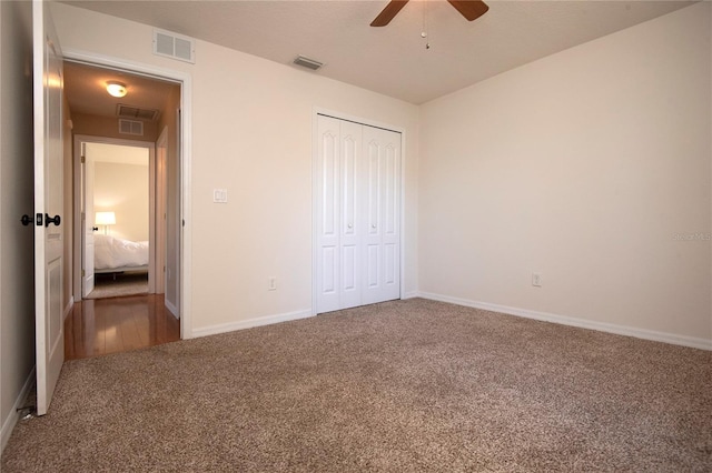 unfurnished bedroom featuring baseboards, visible vents, a closet, and carpet