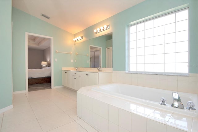 ensuite bathroom featuring tile patterned floors, visible vents, a bath, and vanity