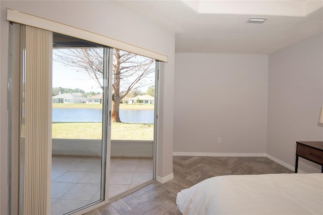 bedroom featuring visible vents, access to exterior, a water view, and multiple windows