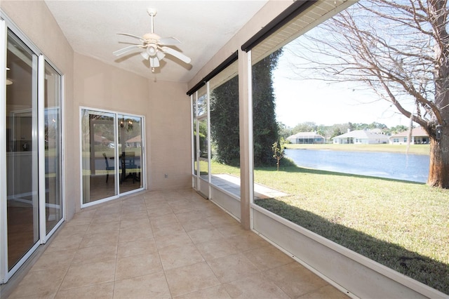 unfurnished sunroom featuring a ceiling fan and a water view