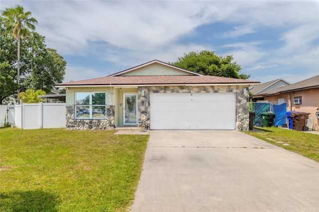 1343 Rocky Rd, Kissimmee, FL 34744 - ranch-style home featuring driveway, stone siding, fence, a front lawn, and a garage