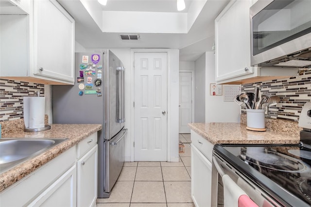 1343 Rocky Rd, Kissimmee, FL 34744 - kitchen featuring visible vents, stainless steel appliances, white cabinets, and light tile patterned floors