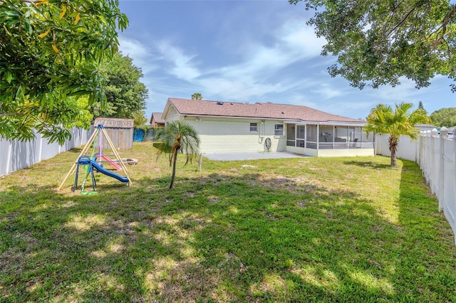 1343 Rocky Rd, Kissimmee, FL 34744 - rear view of property featuring a patio area, a fenced backyard, a yard, and a sunroom