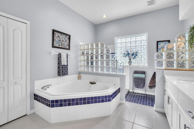full bath with vanity, baseboards, visible vents, tile patterned flooring, and a garden tub