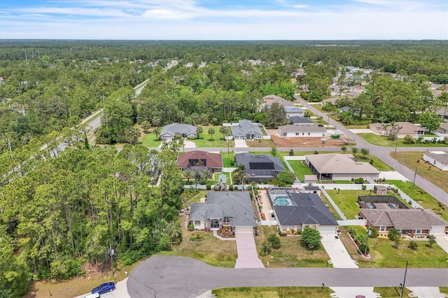 drone / aerial view with a wooded view and a residential view