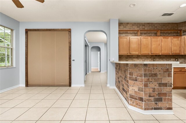 8231 SW 79th Ct, Ocala, FL 34476 - kitchen featuring light tile patterned floors, ceiling fan, visible vents, light countertops, and arched walkways