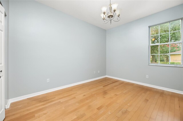 8231 SW 79th Ct, Ocala, FL 34476 - spare room with a chandelier, baseboards, and light wood finished floors
