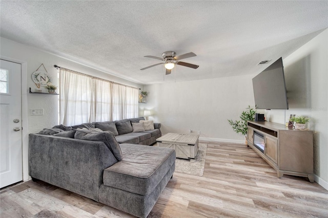 living room with visible vents, ceiling fan, a textured ceiling, and light wood finished floors