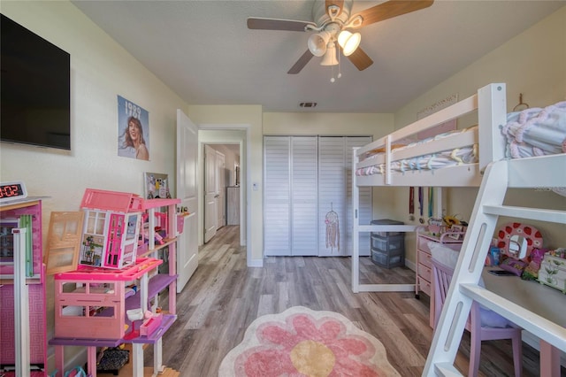 bedroom with a closet, visible vents, ceiling fan, and wood finished floors