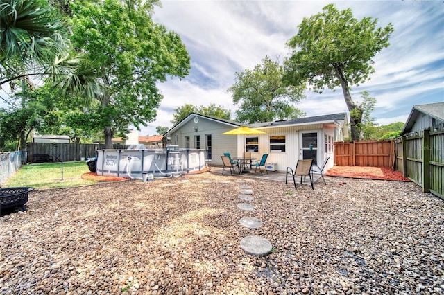 back of house featuring a fenced backyard, a patio, and a fenced in pool