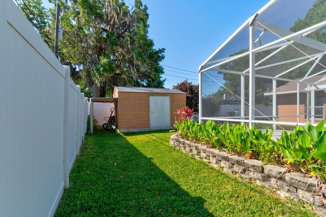 view of yard featuring a lanai, an outdoor structure, a shed, and a fenced backyard