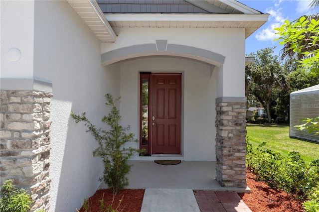 property entrance featuring stucco siding and stone siding