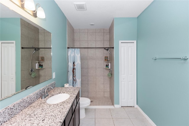 bathroom featuring vanity, tile patterned flooring, a shower stall, and a closet