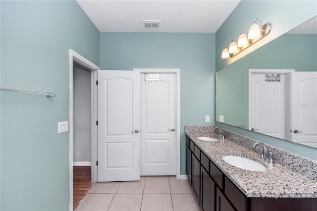 bathroom featuring visible vents, a sink, baseboards, and double vanity