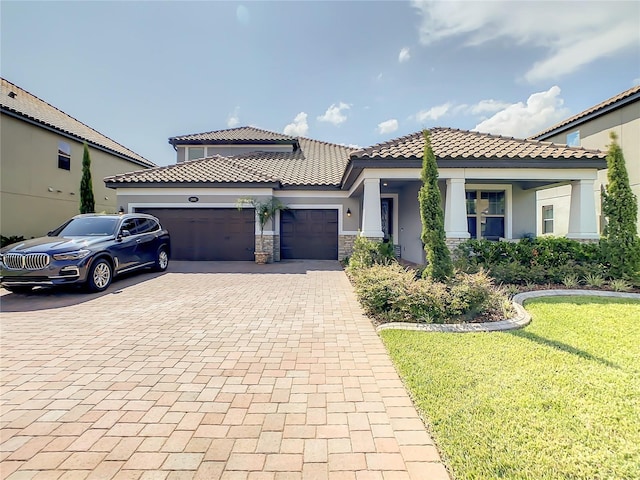 260 Teddy Rushing St, Debary, FL 32713 - mediterranean / spanish house with a garage, a front lawn, stone siding, decorative driveway, and stucco siding