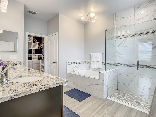260 Teddy Rushing St, Debary, FL 32713 - full bathroom with a walk in closet, a bath, a shower stall, wood finished floors, and vanity