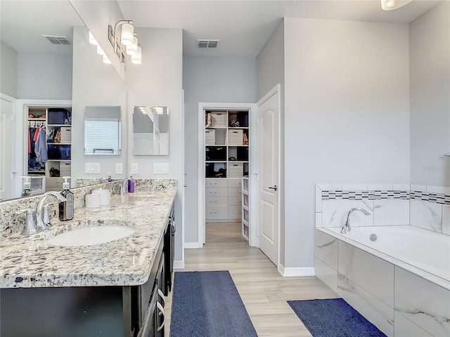 260 Teddy Rushing St, Debary, FL 32713 - bathroom featuring visible vents, a walk in closet, wood finished floors, and vanity