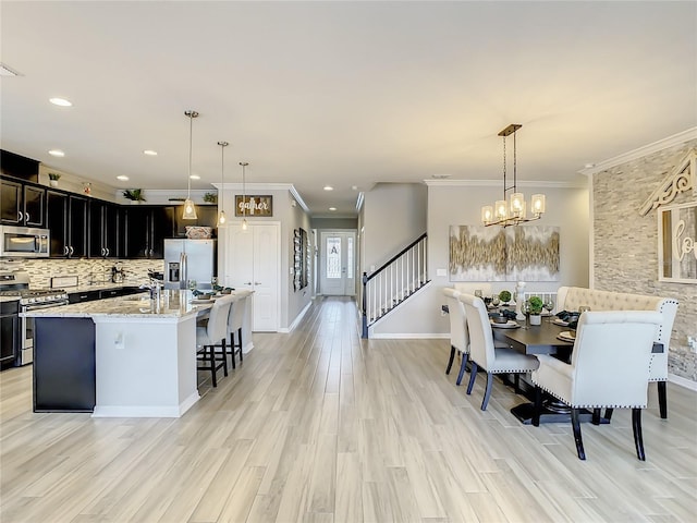 260 Teddy Rushing St, Debary, FL 32713 - dining room featuring crown molding, a notable chandelier, light wood-style flooring, baseboards, and stairway