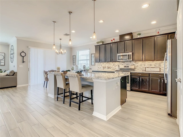 260 Teddy Rushing St, Debary, FL 32713 - kitchen with a kitchen island with sink, a breakfast bar area, stainless steel appliances, decorative backsplash, and ornamental molding