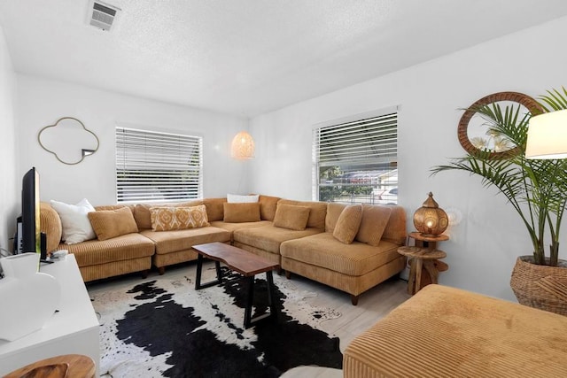 living area with light wood-type flooring and visible vents