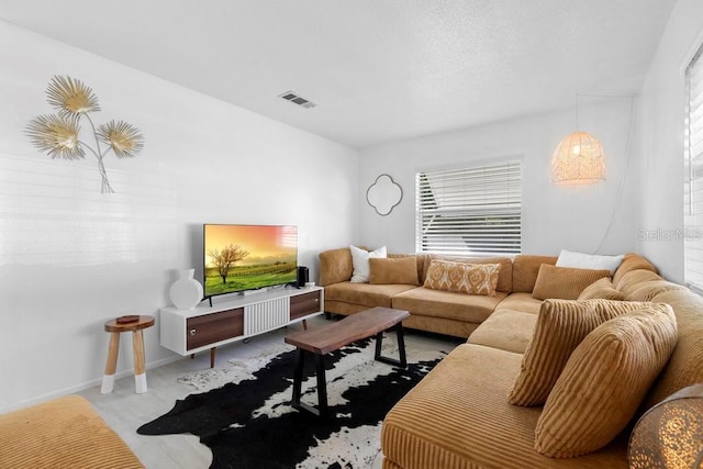 living area with baseboards and visible vents