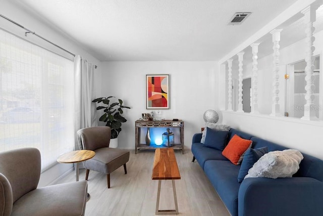 living area featuring light wood-type flooring and visible vents
