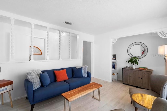 living room featuring baseboards, visible vents, and light wood-style floors