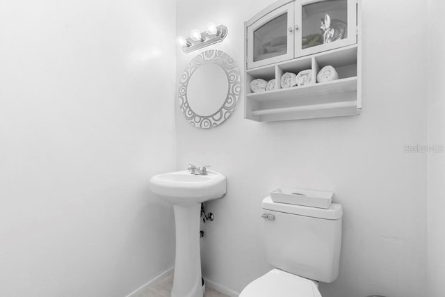 bathroom with toilet and baseboards