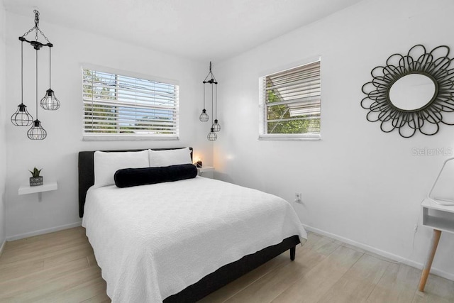 bedroom with baseboards and light wood-style flooring