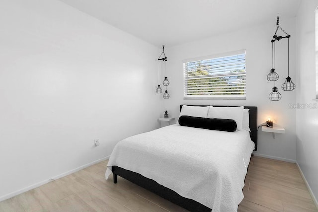 bedroom with baseboards and wood finished floors