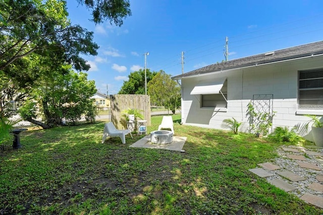 view of yard featuring an outdoor fire pit, a patio area, and fence