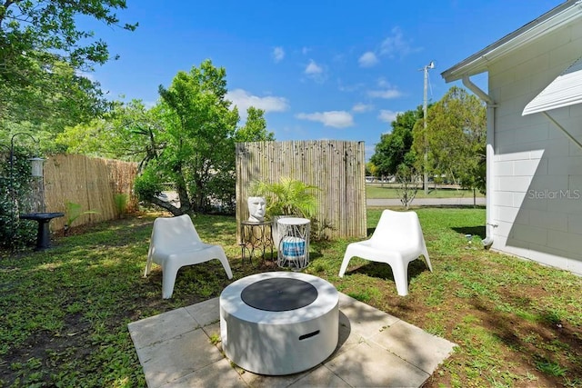 view of yard with a patio area, a fire pit, and fence