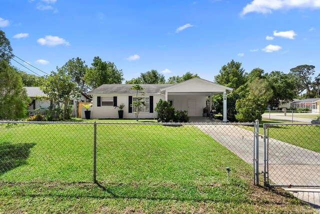 ranch-style house featuring concrete driveway, a front lawn, fence, and a carport