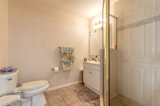 full bathroom featuring vanity, tile patterned floors, toilet, a tile shower, and a textured ceiling