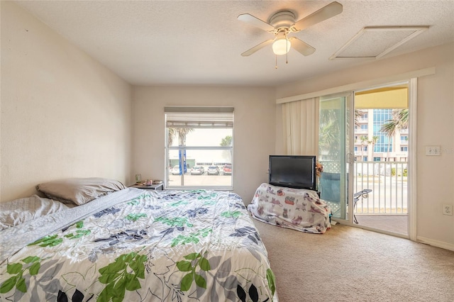 carpeted bedroom with attic access, a ceiling fan, access to outside, and a textured ceiling