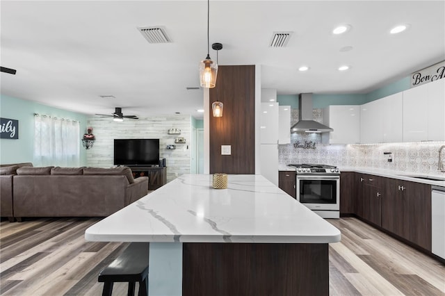 2824 Oak Lea Dr, South Daytona, FL 32119 - kitchen with a sink, wall chimney exhaust hood, stainless steel appliances, open floor plan, and visible vents
