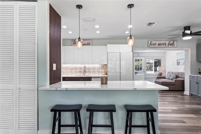 2824 Oak Lea Dr, South Daytona, FL 32119 - kitchen with a kitchen bar, visible vents, a sink, a peninsula, and open floor plan
