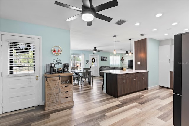 2824 Oak Lea Dr, South Daytona, FL 32119 - kitchen with visible vents, light countertops, ceiling fan, and dark brown cabinetry