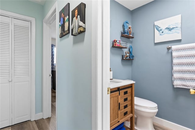 2824 Oak Lea Dr, South Daytona, FL 32119 - bathroom with wood finished floors, vanity, baseboards, a closet, and toilet