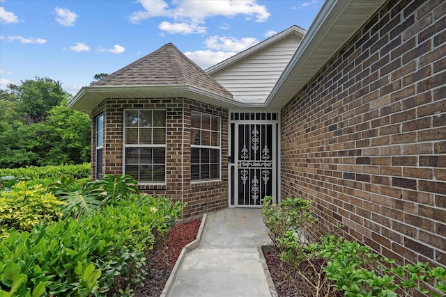 30 Reflections Village Dr, Ormond Beach, FL 32174 - view of exterior entry featuring brick siding and roof with shingles