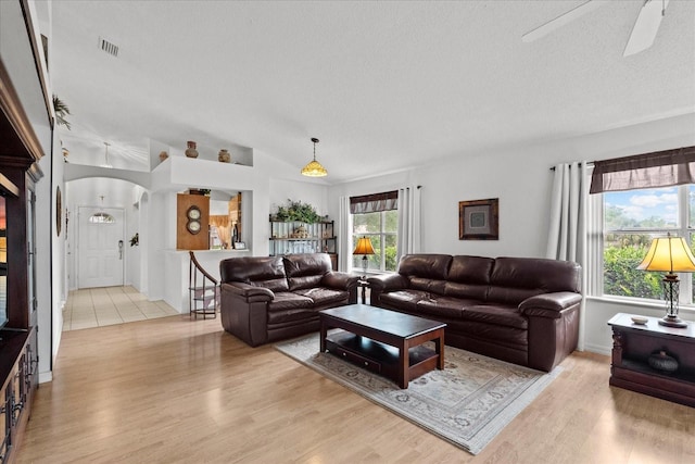 30 Reflections Village Dr, Ormond Beach, FL 32174 - living room featuring ceiling fan, arched walkways, a textured ceiling, lofted ceiling, and light wood-type flooring