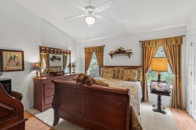 30 Reflections Village Dr, Ormond Beach, FL 32174 - bedroom with ceiling fan, vaulted ceiling, light wood finished floors, and a textured ceiling